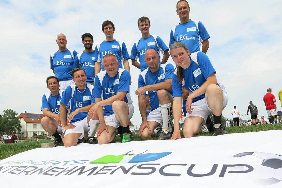 Eine Gruppe von Sportlern posiert gemeinsam für ein Foto, lächelnd und in fröhlicher Stimmung.